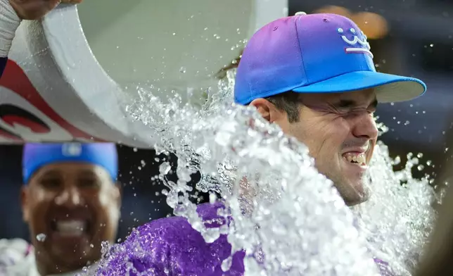 Kansas City Royals starting pitcher Cole Ragans is doused by Salvador Perez after their baseball game against the Los Angeles Angels, Saturday, April 25, 2026, in Kansas City, Mo. (AP Photo/Charlie Riedel)