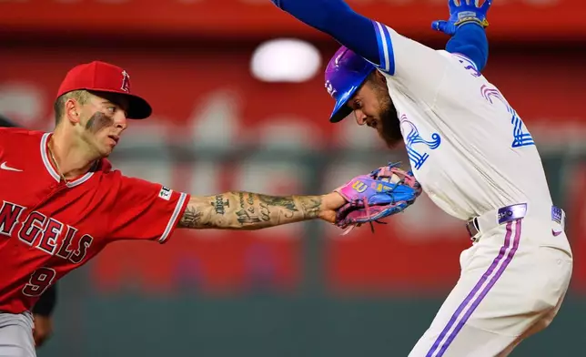 Kansas City Royals' Kyle Isbel is tagged out by Los Angeles Angels shortstop Zach Neto (9) after getting caught off base during the seventh inning of a baseball game Saturday, April 25, 2026, in Kansas City, Mo. (AP Photo/Charlie Riedel)