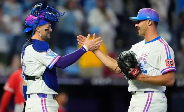 Kansas City Royals catcher Carter Jensen, left, and relief pitcher Mason Black celebrate after their baseball game against the Los Angeles Angels, Saturday, April 25, 2026, in Kansas City, Mo. (AP Photo/Charlie Riedel)