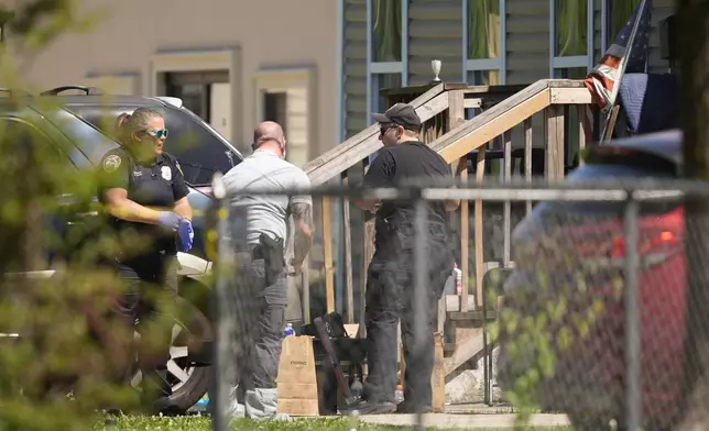 Police work outside a house in Shreveport, La., that is one of the locations tied to a mass shooting Sunday, April 19, 2026. (AP Photo/Gerald Herbert)