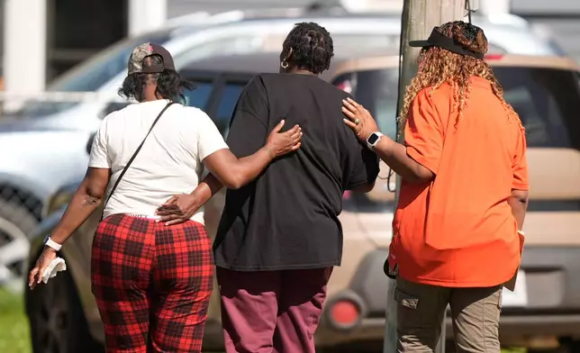 People are consoled outside the scene of a mass shooting, Sunday, April 19, 2026, in Shreveport, La. (AP Photo/Gerald Herbert)