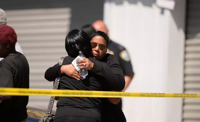 Council woman Tabatha Taylor, right, hugs an unknown person outside the scene of a mass shooting in Shreveport, La., Sunday, April 19, 2026. (AP Photo/Gerald Herbert)