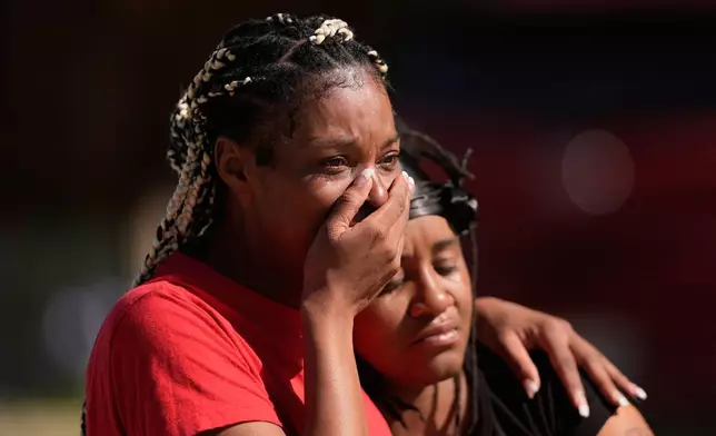 People grieve as they comfort each other outside the scene of a mass shooting, Sunday, April 19, 2026, in Shreveport, La. (AP Photo/Gerald Herbert)