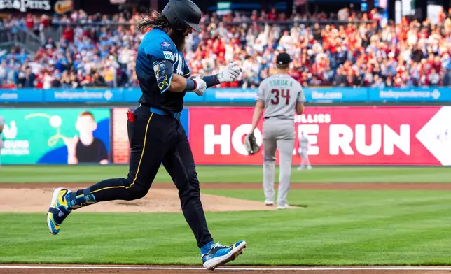 Philadelphia Phillies' Brandon Marsh, left, runs the bases after hitting a three-run home run off Arizona Diamondbacks starting pitcher Mike Soroka (34) during the first inning of a baseball game, Friday, April 10, 2026, in Philadelphia. (AP Photo/Chris Szagola)