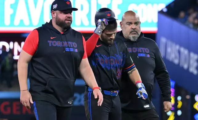 Toronto Blue Jays' Nathan Lukes, centre, leaves the game after getting injured sliding into second base against the Cleveland Guardians in first inning of a baseball game in Toronto on Friday, April 24, 2026. (Jon Blacker/The Canadian Press via AP)