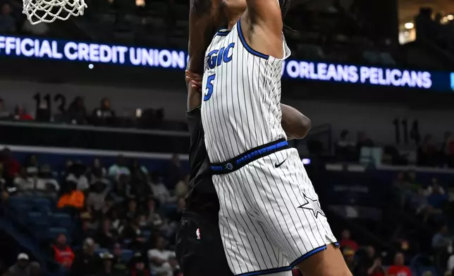 Orlando Magic forward Paolo Banchero (5) dunks in the second half against the New Orleans Pelicans in an NBA basketball game in New Orleans, Sunday, April 5, 2026. (AP Photo/Ella Hall)
