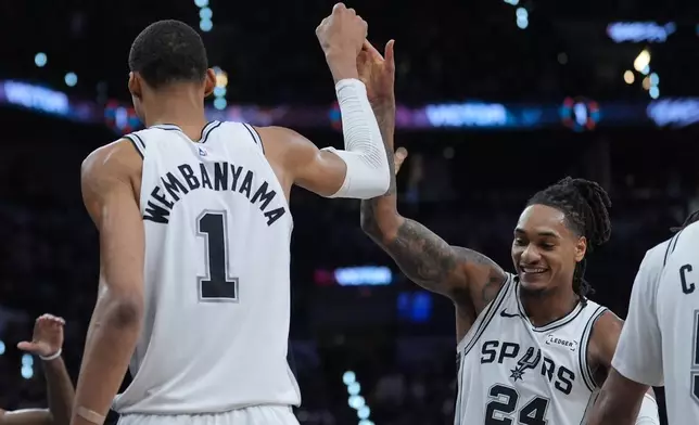 San Antonio Spurs forward/center Victor Wembanyama (1) reacts with guard/forward Devin Vassell (24) during the second half in Game 5 of a first-round NBA playoffs basketball series against the Portland Trail Blazers, in San Antonio, Tuesday, April 28, 2026. (AP Photo/Eric Gay)