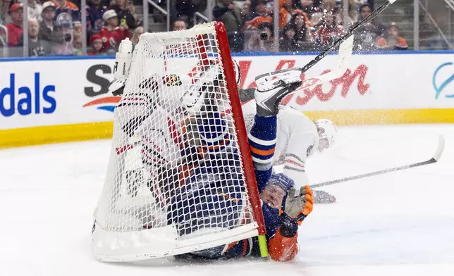 Chicago Blackhawks goalie Spencer Knight (30) makes the save as Sam Rinzel (6) and Edmonton Oilers' Trent Frederic (10) crash the net during the second period of an NHL game, in Edmonton on Thursday April 2, 2026. (Jason Franson/The Canadian Press via AP)