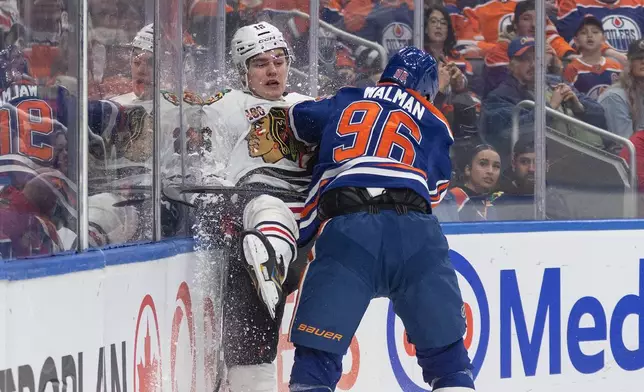 Chicago Blackhawks' Anton Frondell (16) is checked by Edmonton Oilers' Jake Walman (96) during the first period of an NHL hockey game in Edmonton, Alberta, on Thursday April 2, 2026. (Jason Franson/The Canadian Press via AP)