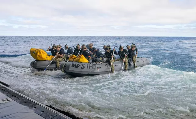In this photo provided by NASA, U.S. Navy divers prepare to deploy in small boats from the well deck of USS John P. Murtha to recover Artemis II crew members NASA astronauts Reid Wiseman, commander; Victor Glover, pilot; Christina Koch, mission specialist; and CSA (Canadian Space Agency) astronaut Jeremy Hansen, mission specialist and NASA's Orion spacecraft in the Pacific Ocean off the coast of California, Friday, April 10, 2026. (Bill Ingalls/NASA via AP)