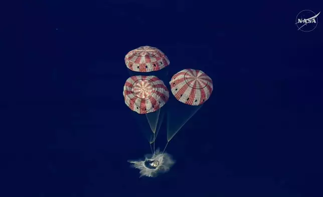 In this image from video provided by NASA, the Artemis II Orion capsule splashes down in the Pacific Ocean, on Friday, April 10, 2026. (NASA via AP)
