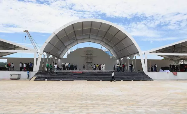 People walk on a stage set by the Church of Our Lady of Muxima in Muxima, Angola, Saturday, April 11, 2026 which Pope Leo XIV will visit during his 11-day pastoral visit to Africa. (AP Photo)