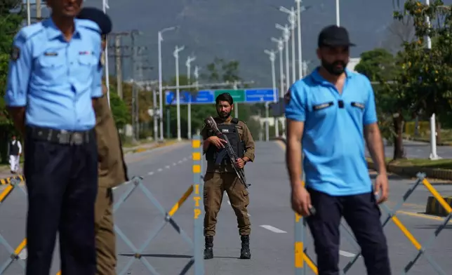 Police officers stand guard at a checkpoint on a barricaded to ensure security ahead of the second round of negotiations between the U.S. and Iran, in Islamabad, Pakistan, Tuesday, April 21, 2026. (AP Photo/Anjum Naveed)