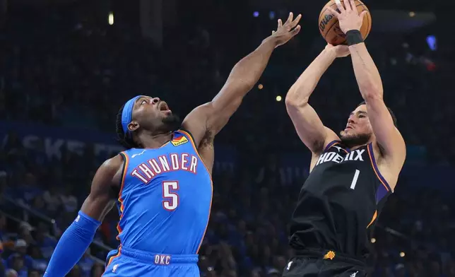Phoenix Suns guard Devin Booker (1) looks to shoot over Oklahoma City Thunder guard Luguentz Dort (5) during the first half in Game 1 of a first-round NBA playoffs basketball series Sunday, April 19, 2026, in Oklahoma City. (AP Photo/Nate Billings)