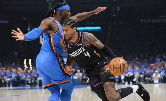 Phoenix Suns guard Jalen Green (4) drives against Oklahoma City Thunder guard Luguentz Dort, left, during the first half in Game 1 of a first-round NBA playoffs basketball series Sunday, April 19, 2026, in Oklahoma City. (AP Photo/Nate Billings)