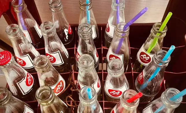 A plastic crate filled with empty bottles of Iranian soft drinks sits on the floor of a roadside restaurant near Sinur, Iran, Saturday, April 4, 2026. (AP Photo/Francisco Seco)