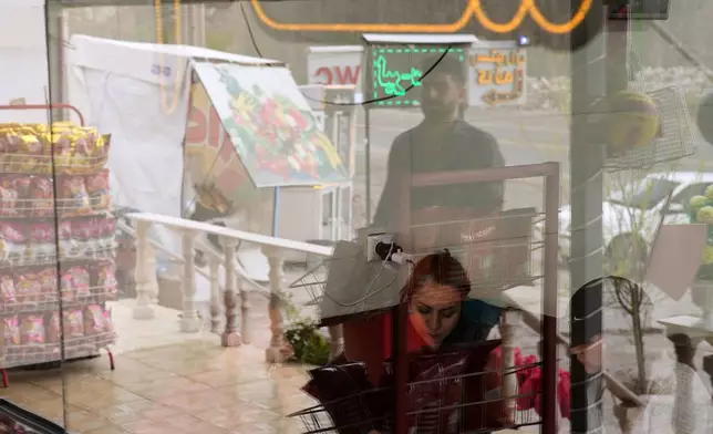 A family eats breakfast at a roadside restaurant near Sinur, Iran, Saturday, April 4, 2026. (AP Photo/Francisco Seco)