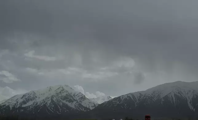 Backdropped by snow-covered mountains, vehicles drive along a highway between Khoy and Marand, Iran, Saturday, April 4, 2026. (AP Photo/Francisco Seco)