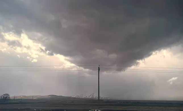 Dark clouds gather over a parked car along the roadside between Tabriz and Zanjan, Iran, Saturday, April 4, 2026. (AP Photo/Francisco Seco)