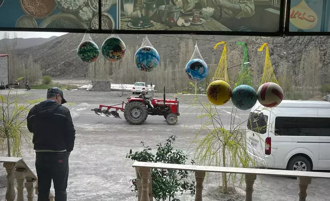 A man drives a tractor past a roadside restaurant near Sinur, Iran, Saturday, April 4, 2026. (AP Photo/Francisco Seco)