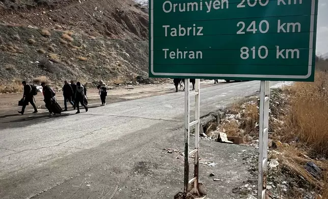 Travelers arrive at a border crossing between Turkey and Iran in Razi, Iran, Saturday, April 4, 2026. (AP Photo/Francisco Seco)