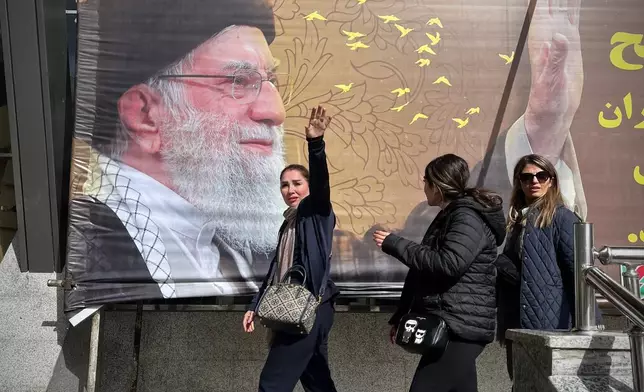 Travelers pass a picture of Iran's slain Supreme Leader Ayatollah Ali Khamenei as they arrive at the border crossing between Turkey and Iran in Razi, Iran, Saturday, April 4, 2026.(AP Photo/Francisco Seco)