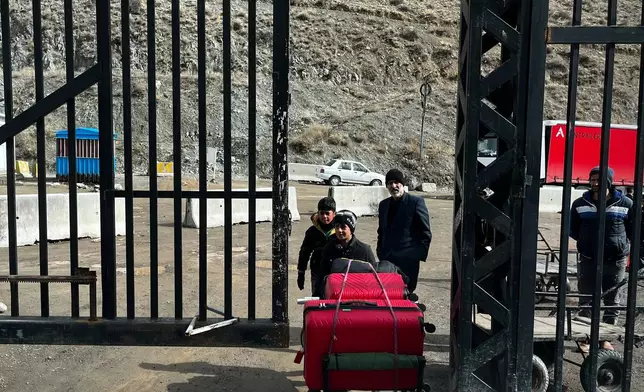 Travelers arrive at a border crossing between Turkey and Iran in Razi, Iran, Saturday, April 4, 2026. (AP Photo/Francisco Seco)