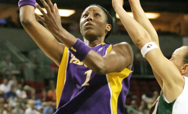 FILE - Los Angeles Sparks' Chamique Holdsclaw, left, drives to the basket past Seattle Storm's Francesca Zara of Italy, during the first half of a WNBA basketball game in Seattle Sunday, July 31, 2005. (AP Photo/John Froschauer, File)