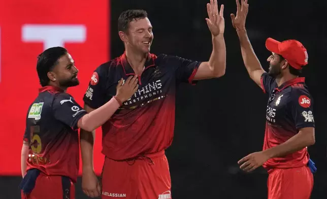 Royal Challengers Bengaluru's Josh Hazlewood, center, celebrate with teammates the wicket of Delhi Capitals' Sameer Rizvi during the Indian Premier League cricket match between Delhi Capitals and Royal Challengers Bengaluru in Delhi, India, Monday, April 27, 2026. (AP Photo/Manish Swarup)