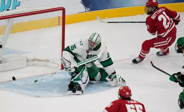 Wisconsin forward Ryan Botterill (21) scores against North Dakota goaltender Jan Spunar (35) in the first period of a semifinal game of the NCAA Frozen Four men's college hockey tournament Thursday, April 9, 2026, in Las Vegas. (AP Photo/John Locher)