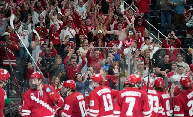 Fans celebrate after Wisconsin defeated North Dakota in a semifinal game of the NCAA Frozen Four men's college hockey tournament Thursday, April 9, 2026, in Las Vegas. (AP Photo/John Locher)