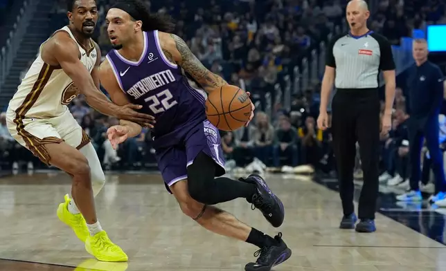 Sacramento Kings guard Devin Carter (22) moves the ball while defended by Golden State Warriors guard De'Anthony Melton during the first half of an NBA basketball game, Tuesday, April 7, 2026, in San Francisco. (AP Photo/Godofredo A. Vásquez)