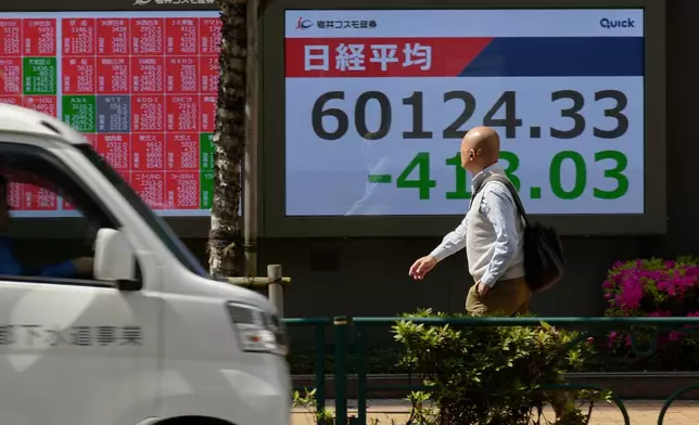 A person walks in front of an electronic stock board showing Japan's Nikkei index at a securities firm, Tuesday, April 28, 2026, in Tokyo. (AP Photo/Eugene Hoshiko)