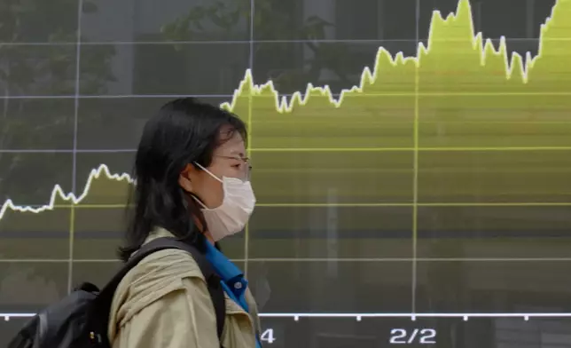 A person walks in front of an electronic stock board showing Japan's Nikkei index at a securities firm Tuesday, April 28, 2026, in Tokyo. (AP Photo/Eugene Hoshiko)