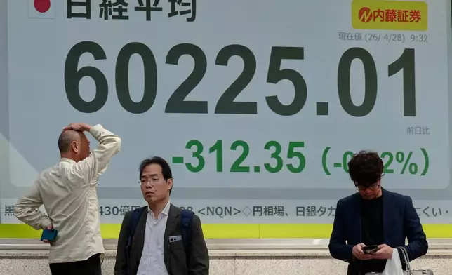 A person looks at an electronic stock board showing Japan's Nikkei index at a securities firm, Tuesday, April 28, 2026, in Tokyo. (AP Photo/Eugene Hoshiko)