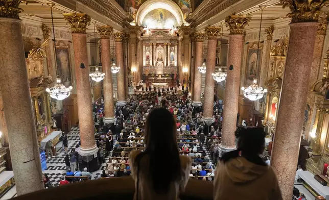 Faithful listen to musicians playing at the Basílica de San José de Flores, where the late Pope Francis worshipped as a youth, on the one-year anniversary of his passing, in Buenos Aires, Argentina, Tuesday, April 21, 2026. (AP Photo/Rodrigo Abd)