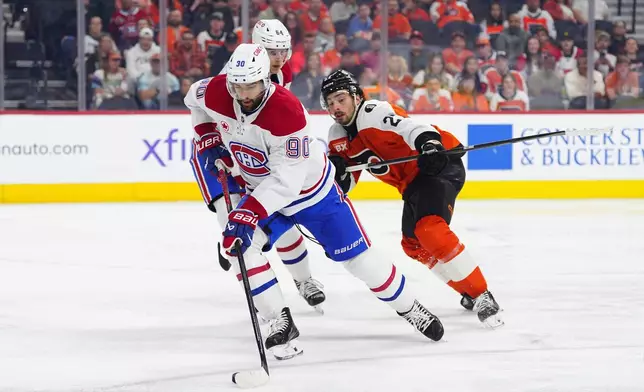 Montréal Canadiens' Joe Veleno skates with the puck past Philadelphia Flyers' Noah Cates (27) during the second period of an NHL hockey game, Tuesday, April 14, 2026, in Philadelphia. (AP Photo/Derik Hamilton)