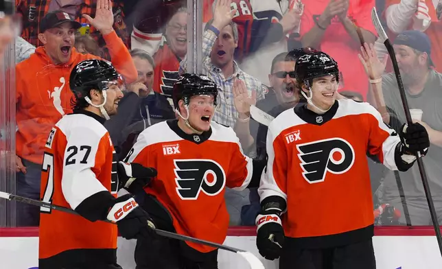 Philadelphia Flyers' Matvei Michkov, center, celebrates his goal with Noah Cates (27) and Oliver Bonk during the second period of an NHL hockey game against the Montréal Canadiens, Tuesday, April 14, 2026, in Philadelphia. (AP Photo/Derik Hamilton)