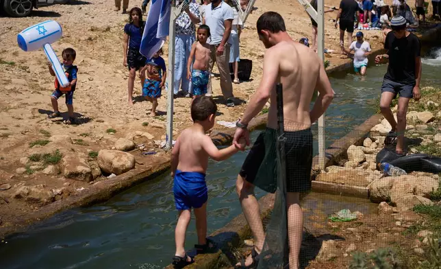 Israeli settlers and others enjoy a day at a spring in the Jordan Valley during Israel's Independence Day, in Auja, in the occupied West Bank, Wednesday, April 22, 2026.(AP Photo/Ohad Zwigenberg)