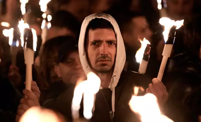 Supporters of Peter Magyar, the leader of the opposition Tisza party hold up their lit phones during a final election rally in Debrecen, Hungary, Saturday, April 11, 2026. (AP Photo/Darko Bandic)