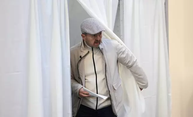 A man prepares to cast his ballot at a polling station in Budapest, Hungary, Sunday, April 12, 2026. (AP Photo/Petr David Josek)
