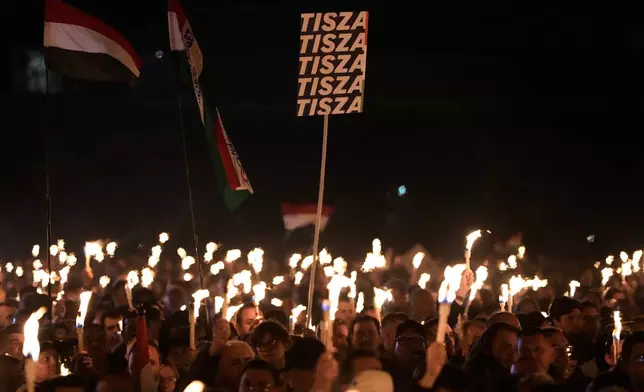 Supporters of Peter Magyar, the leader of the opposition Tisza party hold up their lit phones during a final election rally in Debrecen, Hungary, Saturday, April 11, 2026. (AP Photo/Darko Bandic)