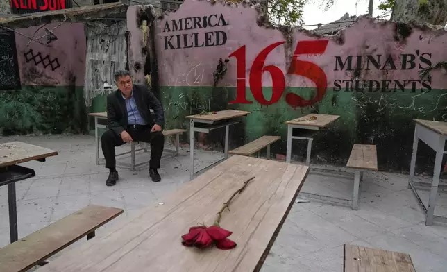 A man sits on a bench in a memorial, set for the school children who were killed during a strike on a school in southern town of Minab on Feb. 28, in northern Tehran, Iran, Sunday, April 12, 2026. (AP Photo/Vahid Salemi)