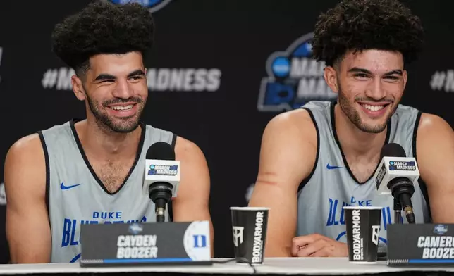 Duke guard Cayden Boozer, left, and Duke forward Cameron Boozer, right, share a laugh during a press conference ahead of a game against UConn in the Elite Eight of the NCAA college basketball tournament Saturday, March 28, 2026, in Washington. (AP Photo/Abbie Parr)
