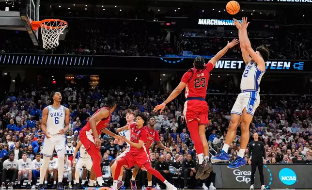 Duke forward Cameron Boozer (12) shoots over St. John's forward Bryce Hopkins (23) during the second half in the Sweet 16 of the NCAA college basketball tournament, Friday, March 27, 2026, in Washington. (AP Photo/Abbie Parr)