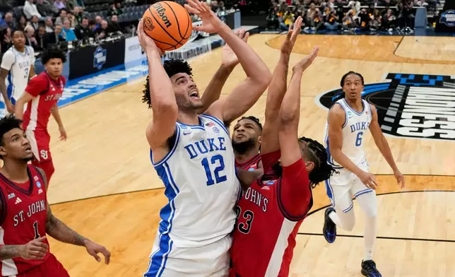 Duke forward Cameron Boozer (12) shoots over St. John's forward Bryce Hopkins (23) during the first half in the Sweet 16 of the NCAA college basketball tournament, Friday, March 27, 2026, in Washington. (AP Photo/Stephanie Scarbrough)
