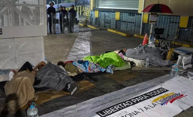 Relatives of detainees camp outside the gates of a Bolivarian National Police detention center, calling for the release of family members who are being held on political grounds, in Caracas, Venezuela, Saturday, Feb. 14, 2026. (AP Photo/Ariana Cubillos)