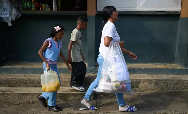Mileidy Mendoza, joined by her son and daughter, arrive to the Yare prison complex to visit her husband, Eric Diaz, where he is being held on political grounds, in San Francisco de Yare, Venezuela, Sunday, April 5, 2026. (AP Photo/Ariana Cubillos)