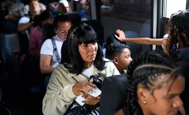 Mileidy Mendoza and her children ride a bus from Caracas to visit her husband, Eric Diaz, imprisoned on political grounds at the Yare prison complex in San Francisco de Yare, Venezuela, Sunday, April 5, 2026. (AP Photo/Ariana Cubillos)