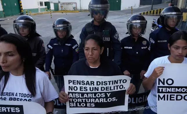 Nelcy Escorcia, center, holds a sign with a message reading in Spanish; “Thinking differently isn’t a crime; isolating and torturing them is”, during a protest outside a detention center where her husband, Franklin Parra, is being held on political grounds, in Caracas, Venezuela, Thursday, Feb. 12, 2026. (AP Photo/Ariana Cubillos)